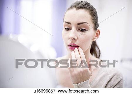 Woman looking at her lips in mirror. View Large Photo Image Stock Photo - Woman looking at her lips in mirror.. Fotosearch