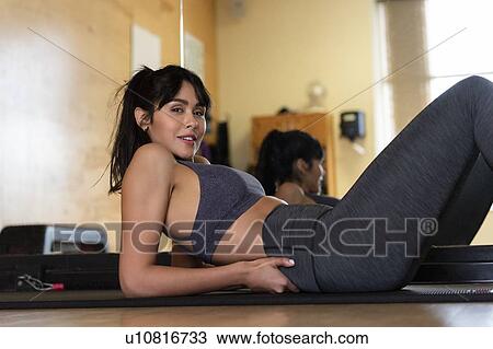 Woman lying on yoga mat View Large Photo Image Stock Image - Woman lying on yoga mat. Fotosearch