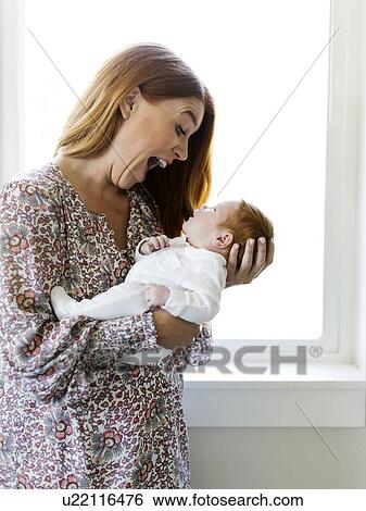 Woman making faces at her newborn son View Large Photo Image Stock Photograph - Woman making faces at her newborn son. Fotosearch
