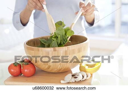 Stock Image - Woman making fresh salad.. Fotosearch
