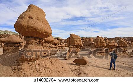 Picture - Woman photographing hoodoos in Goblin Valley State Park, Utah, USA. Fotosearch
