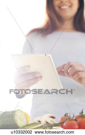 Woman preparing food using digital tablet. View Large Photo Image Stock Image - Woman preparing food using digital tablet.. Fotosearch
