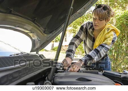 Stock Photo - Woman repairing her car. Fotosearch
