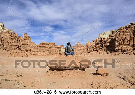 Stock Photograph - Woman sitting on rock in Goblin Valley State Park, Utah, USA. Fotosearch