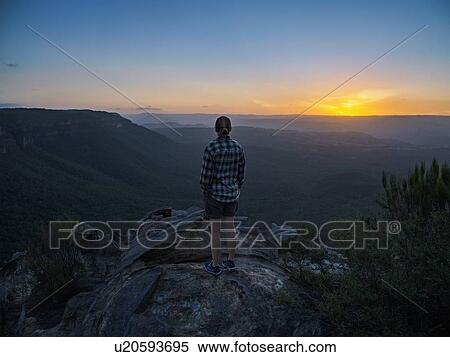 Woman standing on peak of Blue Mountains at sunrise in New South Wales, Australia View Large Photo Image Stock Photography - Woman standing on peak of Blue Mountains at sunrise in New South Wales, Australia. Fotosearch