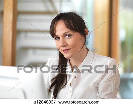 Stock Photo - Woman taking a moment and having a think during her working day in the office. Fotosearch