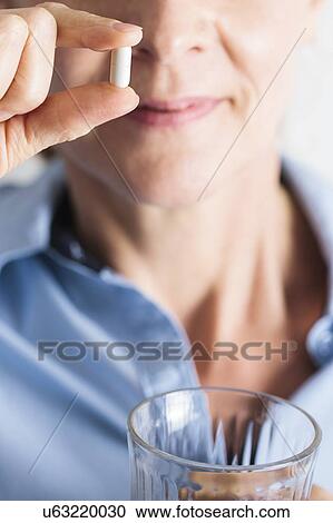 Stock Image - Woman taking ibuprofen anti inflammatory medication.. Fotosearch