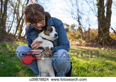 Woman taking pet dog for walk in park View Large Photo Image Picture - Woman taking pet dog for walk in park. Fotosearch