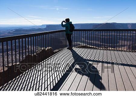 Stock Photograph - Woman taking photograph on observation point in Dead Horse Point State Park in Utah, USA. Fotosearch
