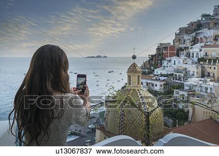 Woman taking photograph using smart phone in Positano, Italy View Large Photo Image Stock Photo - Woman taking photograph using smart phone in Positano, Italy. Fotosearch