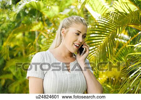 Woman talking on smart phone by palm trees View Large Photo Image Stock Image - Woman talking on smart phone by palm trees. Fotosearch