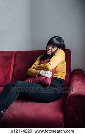 Woman talking on smartphone on sofa View Large Photo Image Stock Photo - Woman talking on smartphone on sofa. Fotosearch