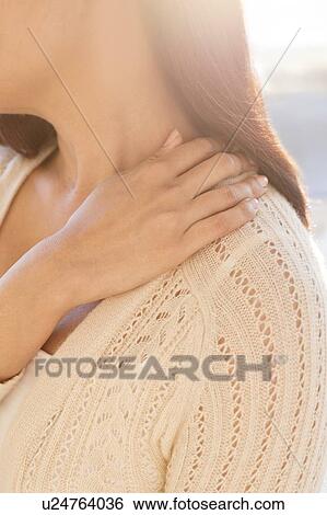 Stock Photograph - Woman touching shoulder in pain.. Fotosearch