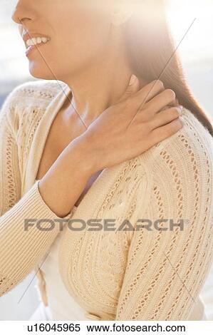 Stock Photography - Woman touching shoulder in pain.. Fotosearch