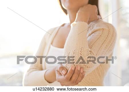 Stock Image - Woman touching sore elbow.. Fotosearch