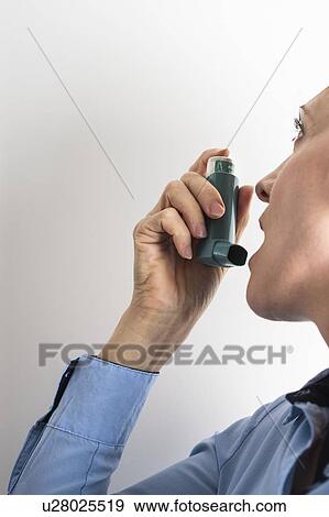 Woman using an inhaler to treat an asthma attack. The inhaler contains bronchodilator drugs, which widen constricted airways in the lungs. View Large Photo Image Stock Photo - Woman using an inhaler to treat an asthma attack. The inhaler contains bronchodilator drugs, which widen constricted airways in the lungs.. Fotosearch