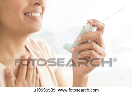 Stock Photography - Woman using inhaler.. Fotosearch