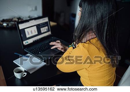 Woman using laptop in home office View Large Photo Image Stock Image - Woman using laptop in home office. Fotosearch