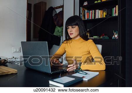 Woman using laptop in home office View Large Photo Image Stock Image - Woman using laptop in home office. Fotosearch