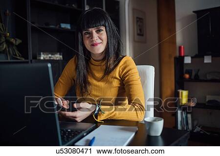 Woman using smartphone in home office View Large Photo Image Stock Image - Woman using smartphone in home office. Fotosearch