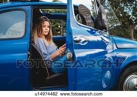 Woman using smartphone inside car View Large Photo Image Stock Image - Woman using smartphone inside car. Fotosearch