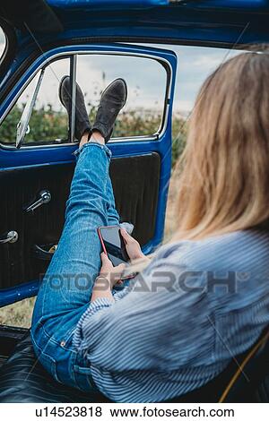 Woman using smartphone inside car View Large Photo Image Stock Photo - Woman using smartphone inside car. Fotosearch