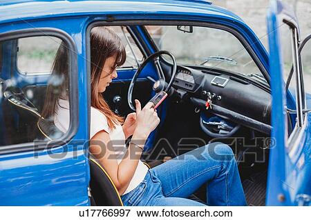 Woman using smartphone inside car View Large Photo Image Stock Photo - Woman using smartphone inside car. Fotosearch
