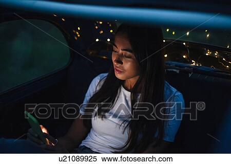 Woman using smartphone inside car View Large Photo Image Stock Photography - Woman using smartphone inside car. Fotosearch