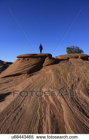 Stock Photography - Woman walking on smooth rock in Monument Valley, Arizona, USA. Fotosearch