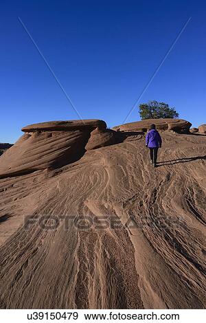 Woman walking on smooth rocks in Monument Valley, Arizona, USA View Large Photo Image Stock Photo - Woman walking on smooth rocks in Monument Valley, Arizona, USA. Fotosearch