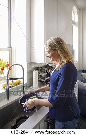 Woman washing vegetables in colander View Large Photo Image Stock Photo - Woman washing vegetables in colander. Fotosearch