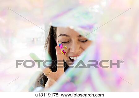 Woman with confetti on cheek making peace gesture View Large Photo Image Stock Photography - Woman with confetti on cheek making peace gesture. Fotosearch