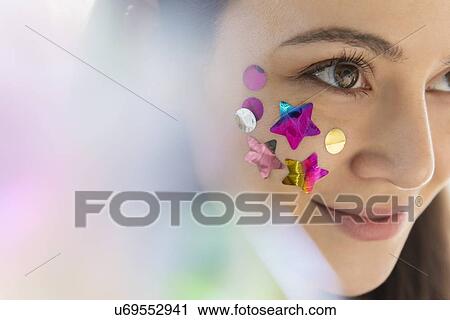 Stock Image - Woman with confetti on cheek. Fotosearch