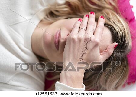 Woman with drawing of closed eyes on her hand View Large Photo Image Stock Image - Woman with drawing of closed eyes on her hand. Fotosearch