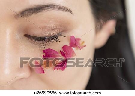 Stock Photograph - Woman with flower petals on cheek. Fotosearch