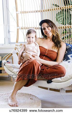 Woman with her baby daughter smiling on hanging chair View Large Photo Image Stock Photo - Woman with her baby daughter smiling on hanging chair. Fotosearch
