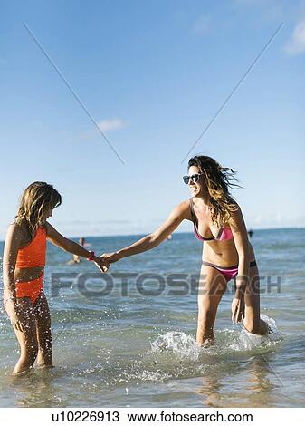 Stock Image - Woman with her daughter on beach. Fotosearch