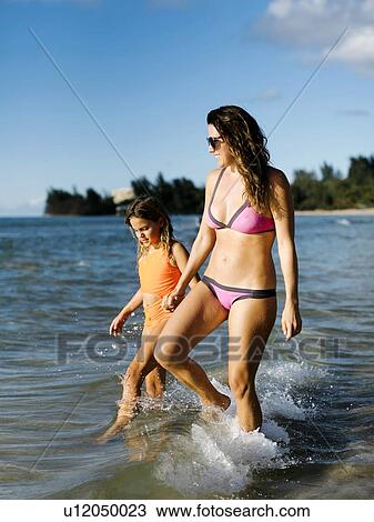 Stock Image - Woman with her daughter on beach. Fotosearch