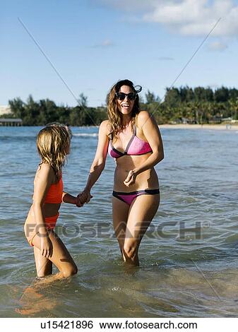 Stock Photograph - Woman with her daughter on beach. Fotosearch
