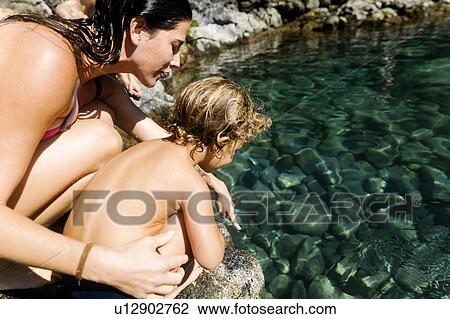 Woman with her son by tide pool View Large Photo Image Stock Image - Woman with her son by tide pool. Fotosearch