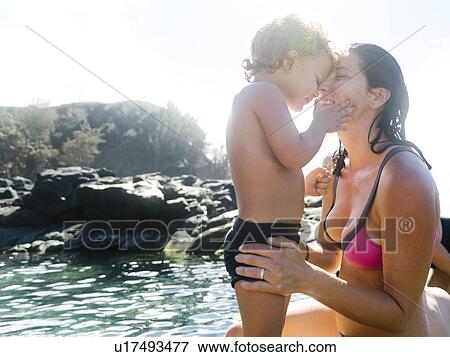 Stock Photo - Woman with her son by tide pool. Fotosearch