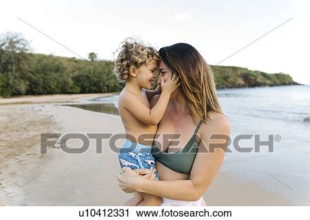 Woman with her son on beach View Large Photo Image Stock Image - Woman with her son on beach. Fotosearch