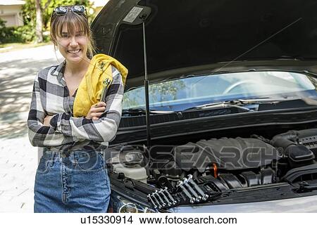 Woman with oil rag beside car View Large Photo Image Picture - Woman with oil rag beside car. Fotosearch
