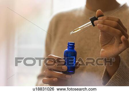 Woman's hand holding pipette and bottle of aromatherapy oil View Large Photo Image Stock Photograph - Woman's hand holding pipette and bottle of aromatherapy oil. Fotosearch