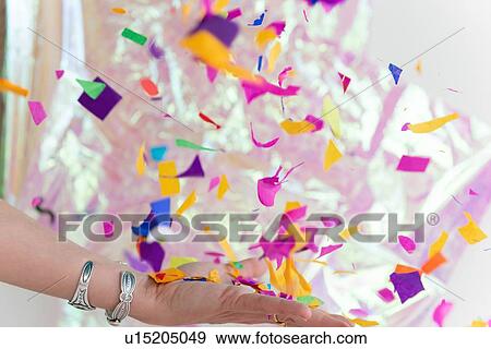 Stock Photo - Woman's hand throwing confetti. Fotosearch