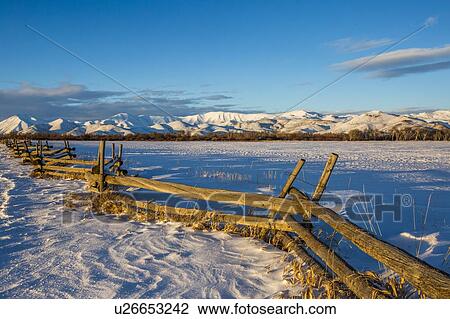 Stock Image - Wooden fence and snow field in Picabo, Idaho. Fotosearch