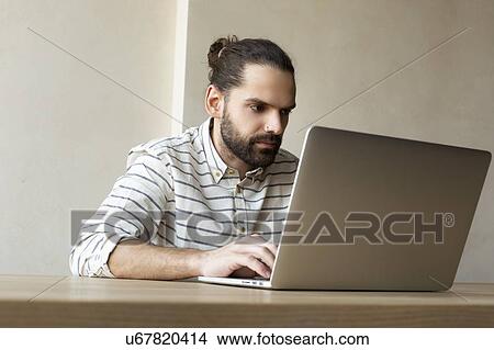 Picture - Young businessman using laptop. Fotosearch