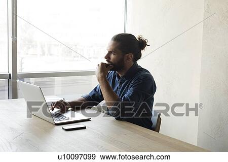 Stock Photo - Young businessman using laptop. Fotosearch