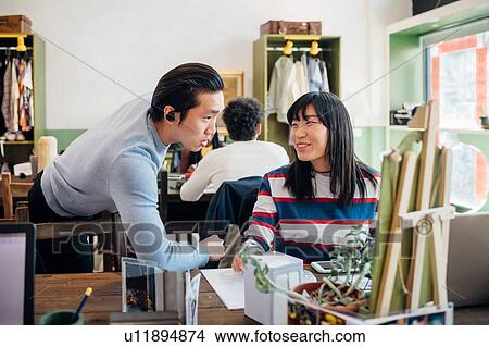 Picture - Young businesswoman and man talking at cafe table. Fotosearch