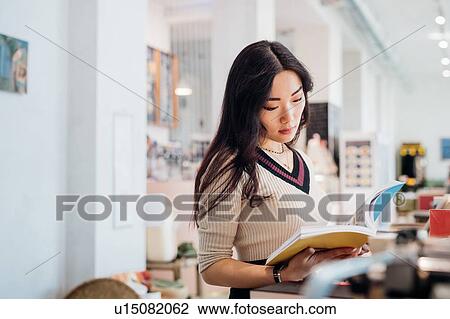 Young businesswoman browsing book in bookshop View Large Photo Image Stock Image - Young businesswoman browsing book in bookshop. Fotosearch